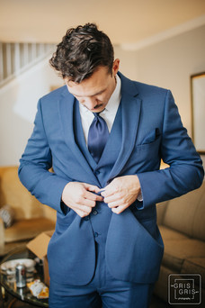 groom gets ready buttoning his jacket