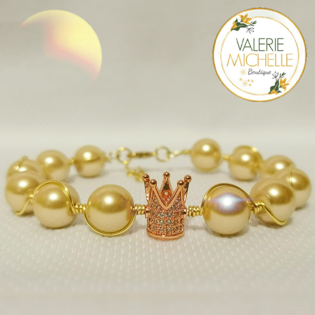 Pulsera artesanal de perlas y corona rosa
