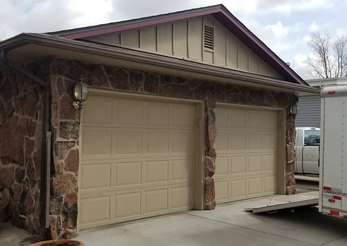 Technician servicing overhead garage door system to ensure proper function and safety