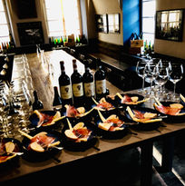 Občerstvení k vinné degustaci, lahve vína a skleničky.