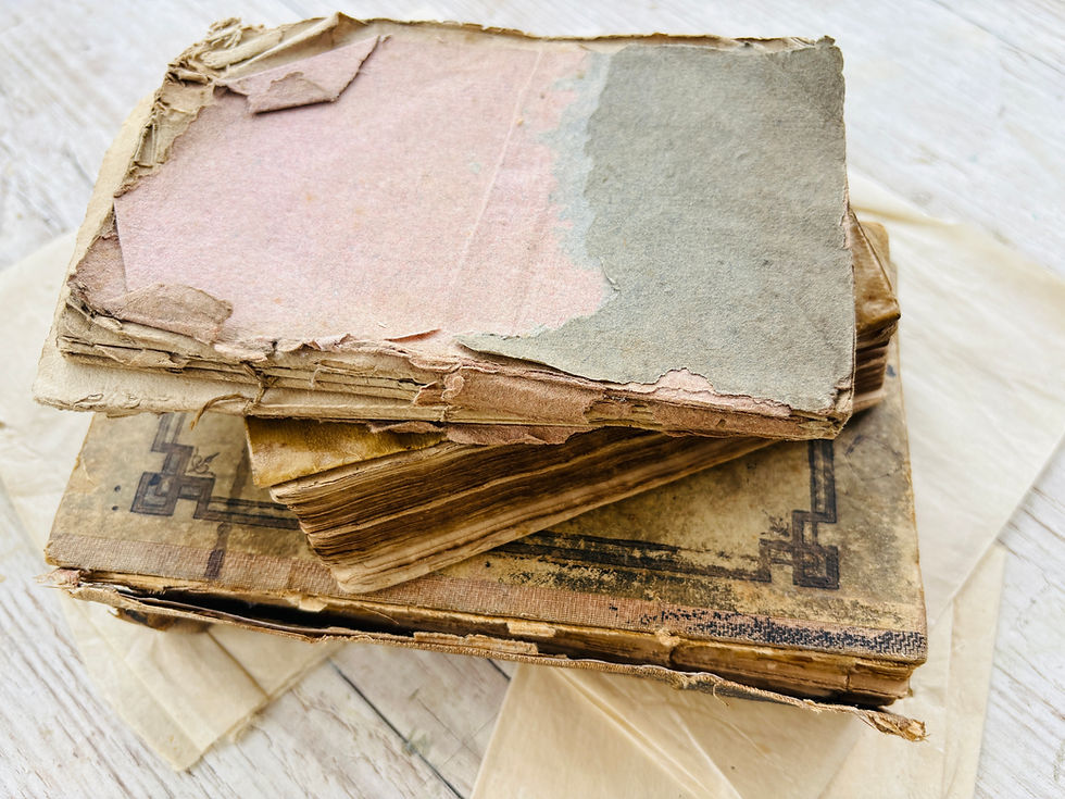 Three old books, stacked on top of each other.