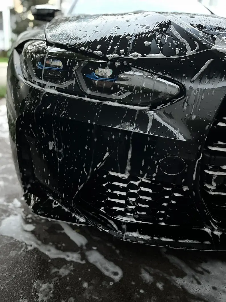 Black car professionally detailed with a deep glossy finish