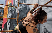 Kala on scaffolding installing mural