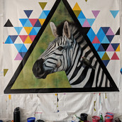 black and white striped zebra painting colorful triangles