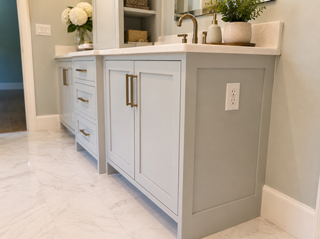 Custom blue vanity cabinetry with finished end panel and marble countertop