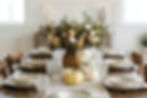 Thanksgiving table with layered neutral linens, crystal glassware, ceramic plates, brass flatware and heirloom pumpkins.