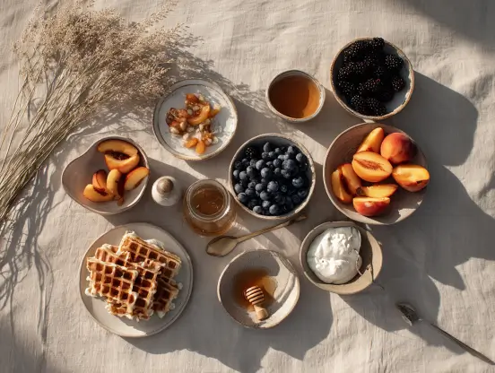 Our favorite kind of summer hosting: a laid-out board of waffles, yogurt, honey, berries, and peache