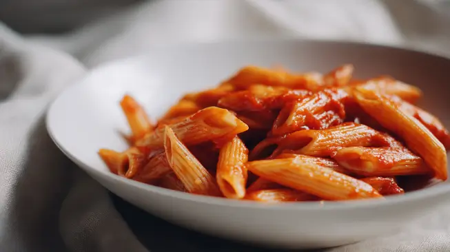 A bowl of warm penne with mild red sauce sits ready for little hands to scoop and serve. These class