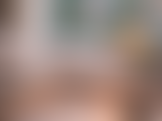 Book and pen on a bed with candle burning on windowsill