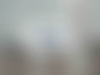 Smokestacks for a coal power plant emit steam into a grey, clouded sky.