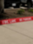 Red fire lane curb freshly painted with white FIRE LANE NO PARKING lettering in Pensacola, FL