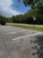 Fresh white parking stall lines painted in a tree lined parking lot in Pensacola, FL