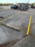 resh yellow parking stall lines and concrete wheel stops with the Milo's Precision Striping truck and trailer on site in Pensacola, FL