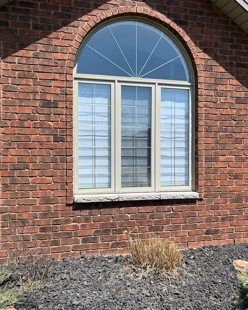 Arched window on a red brick house in Belle River with a new sill and repaired brick below