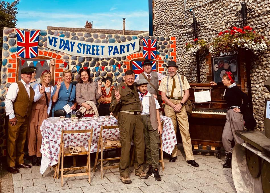 Sheringham visitors posing outside Blyth & Wright in Sheringham on a 1940's weekend