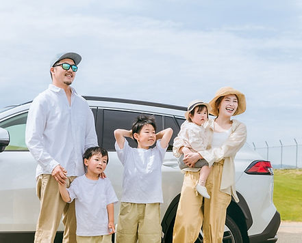 車の前に立つ家族