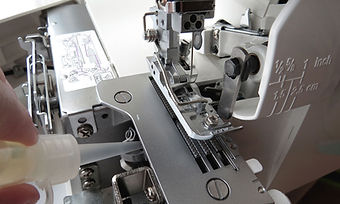 ミシンに油をさすスタッフの手