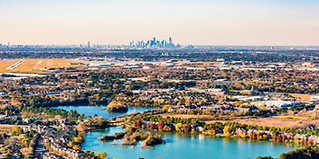 Panoramic photo of Houston in the distance and suburban houses in the forefront