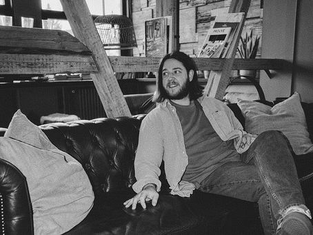 Schwarzweißes Bild von Jes von Neon Hearts Club auf einem Sofa in gemütlicher Atmosphäre – Titelbild zum Blogartikel über die Bedeutung von „Applause“.