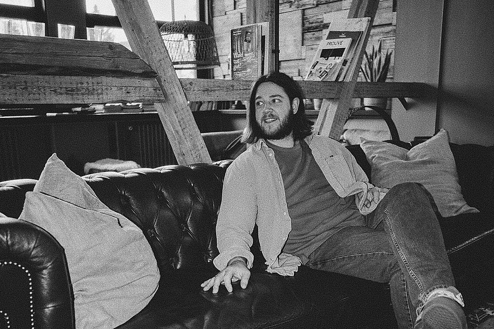 Schwarzweißes Bild von Jes von Neon Hearts Club auf einem Sofa in gemütlicher Atmosphäre – Titelbild zum Blogartikel über die Bedeutung von „Applause“.