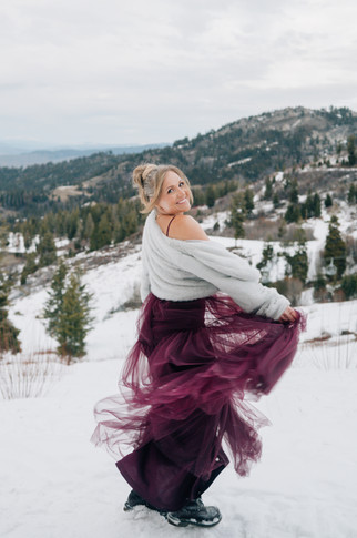 Two women in blue and purple gowns standing in snow at Bogus Basin, Idaho.