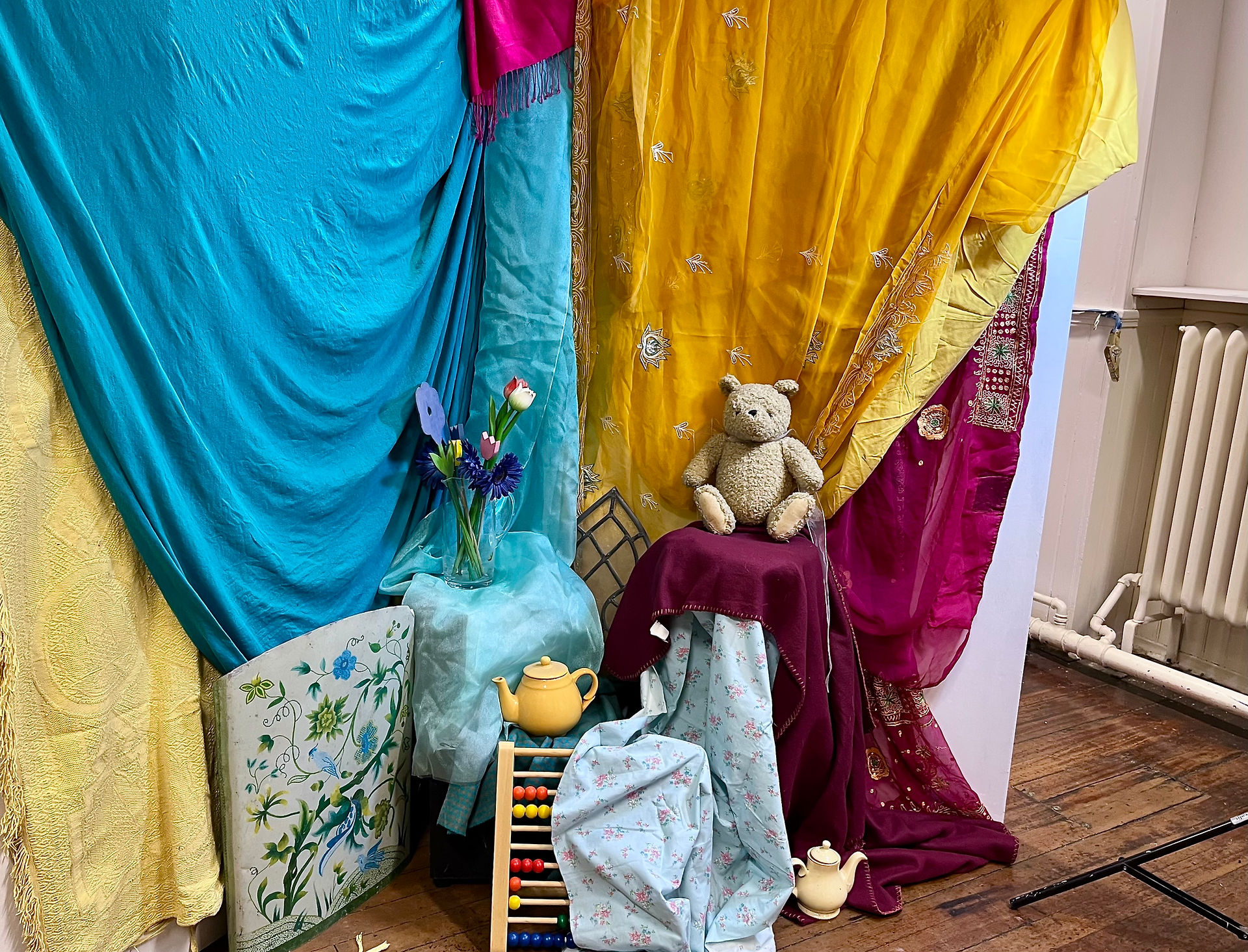 Turquoise and magenta sari drapes with teddy bear and abacus
