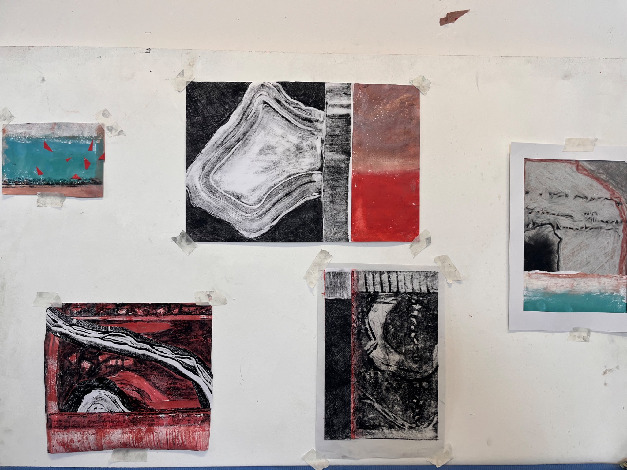 Display of abstract monotypes and mixed-media works in red, turquoise, black and white