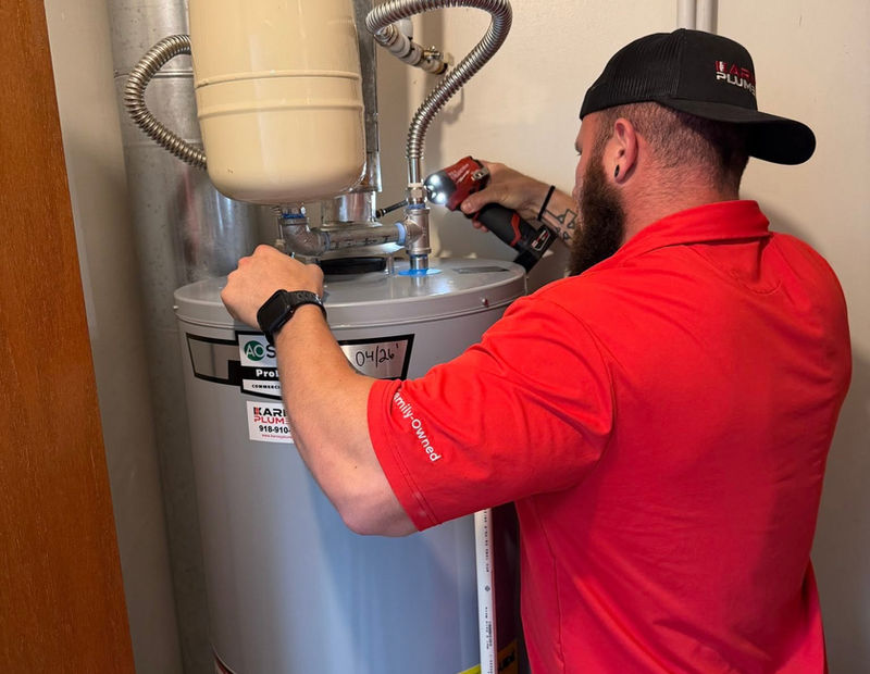 Remington installing a hot water heater in a Tulsa home