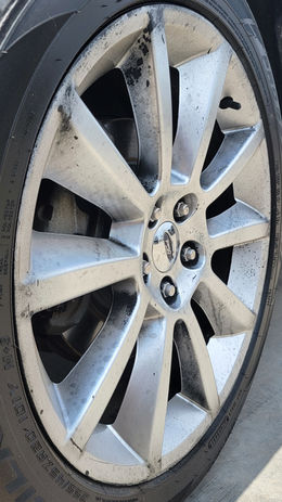 Scratched alloy wheel requiring curb rash repair.
