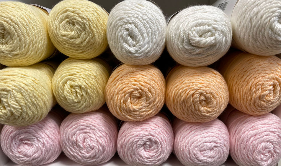 Skeins of yellow, white, orange, and pink