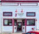 The charming storefront of the Historic Foxhole Tavern, a local landmark in Wilber, Nebraska, established in 1945 and adorned with vibrant red accents.