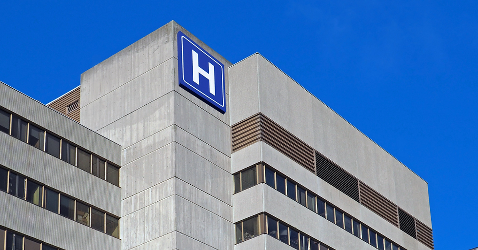 Tall building with "H" sign, indicating a hospital.