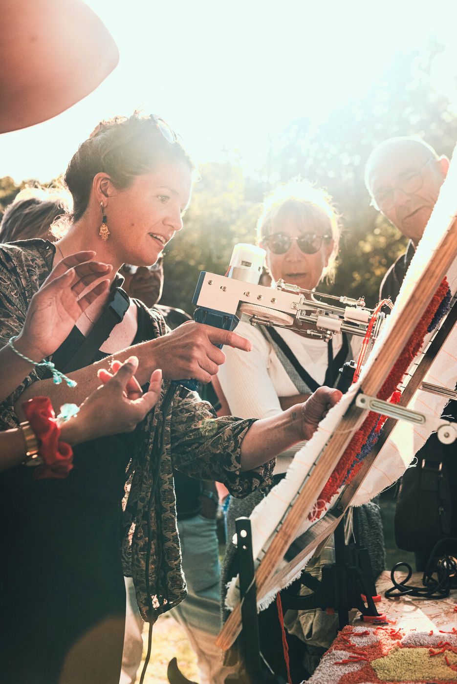 Le public découvre le tufting lors d'une animation en plein air
