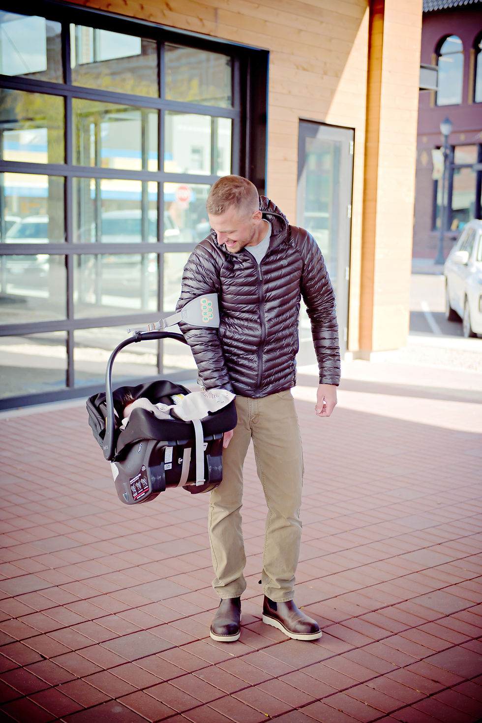 parent using Snug Lug ergonomic strap to carry baby car seat comfortably