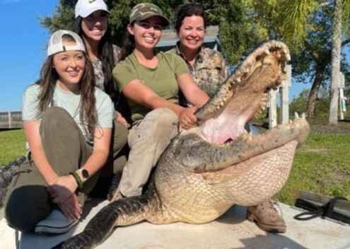 Family posing with a huge alligator