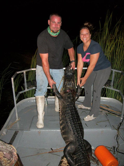 man and woman on a boat with a gator