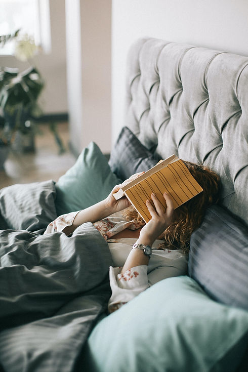 woman-covering-face-with-book-on-bed-152