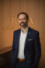 Portrait of Jonathan Huza, lawyer in Real Estate, Wills & Estates, Law Business in Cornwall Ontario, with Huza Law Office sign in the background