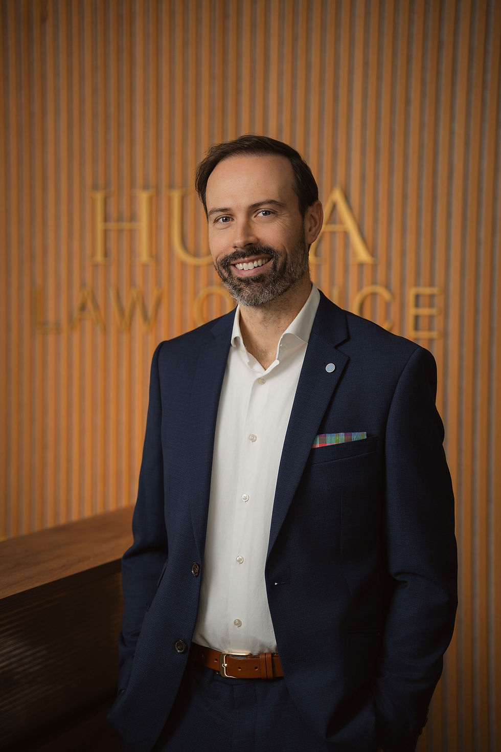 Portrait of Jonathan Huza, lawyer in Real Estate, Wills & Estates, Law Business in Cornwall Ontario, with Huza Law Office sign in the background