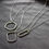 Thumbnail: Silver geometric necklaces on a soft gray velvet background.