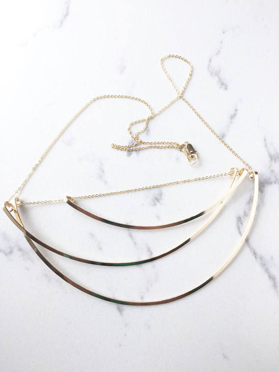 Thumbnail: Gold necklace on a stone white marble background, the chain in clasp are slightly undone.