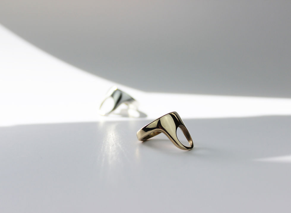 Thumbnail: Gold tone and silver ring side view on a white and grey background. 