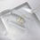 Thumbnail: varying clear resin props with off white background. Flutter necklaces sits almost center of frame, with a side view angle. 