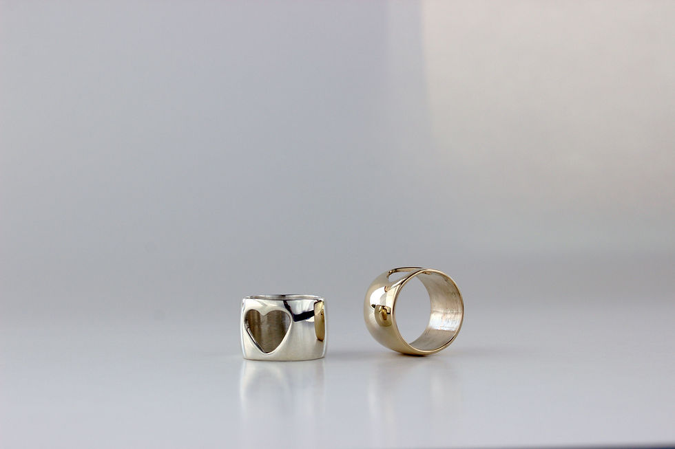 Thumbnail: Silver and gold tone rings on a soft white background. 