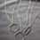 Thumbnail: Silver geometric necklaces on a soft gray velvet background. The chain sparkles in the muted light.