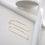 Thumbnail: Gold earrings on an off-white background with various white wooden geometric props in the right and upper part of frame