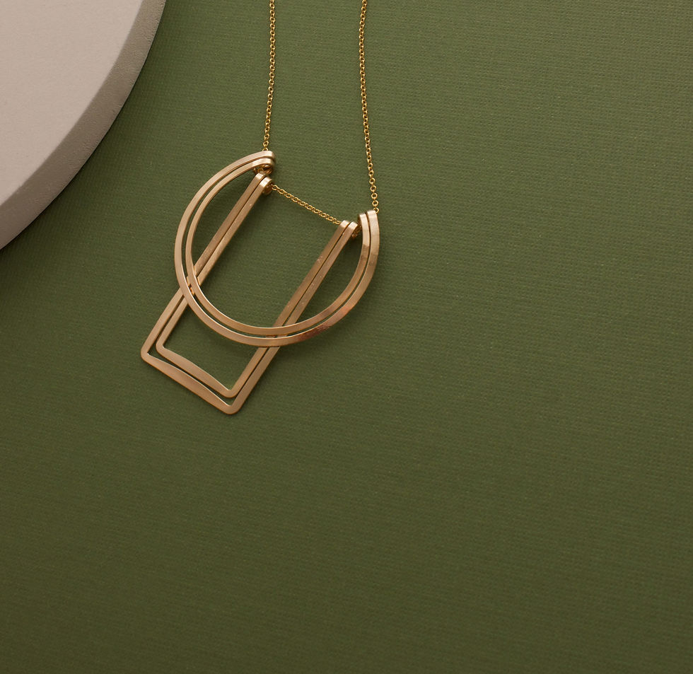 Thumbnail: Gold necklace on an olive green background with a white semi circle in the top left corner of the frame.