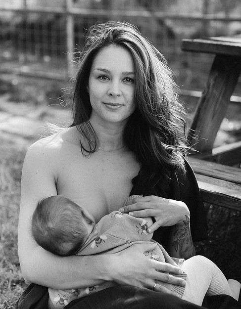 Tanya geeft borstvoeding in de natuur aan 3 maand oude baby.
