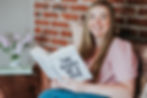 A business owner sitting on the sofa smiling and reading The Diary of CEO