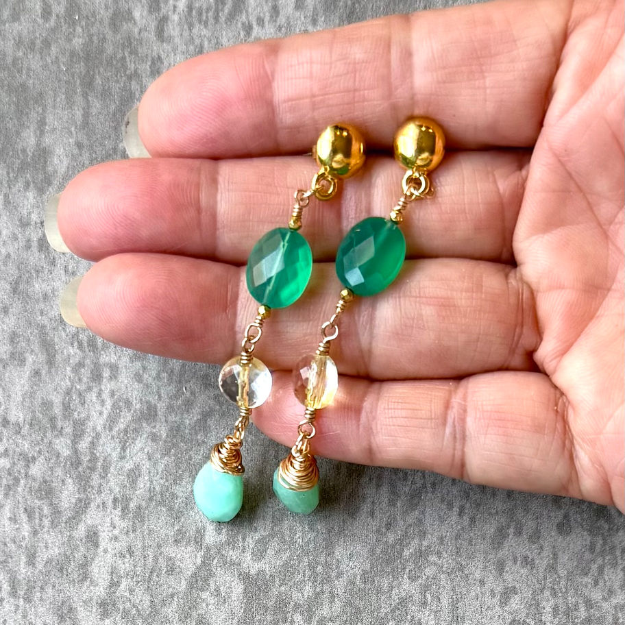 Tres Line Gold Drop Earring on hand for scale.